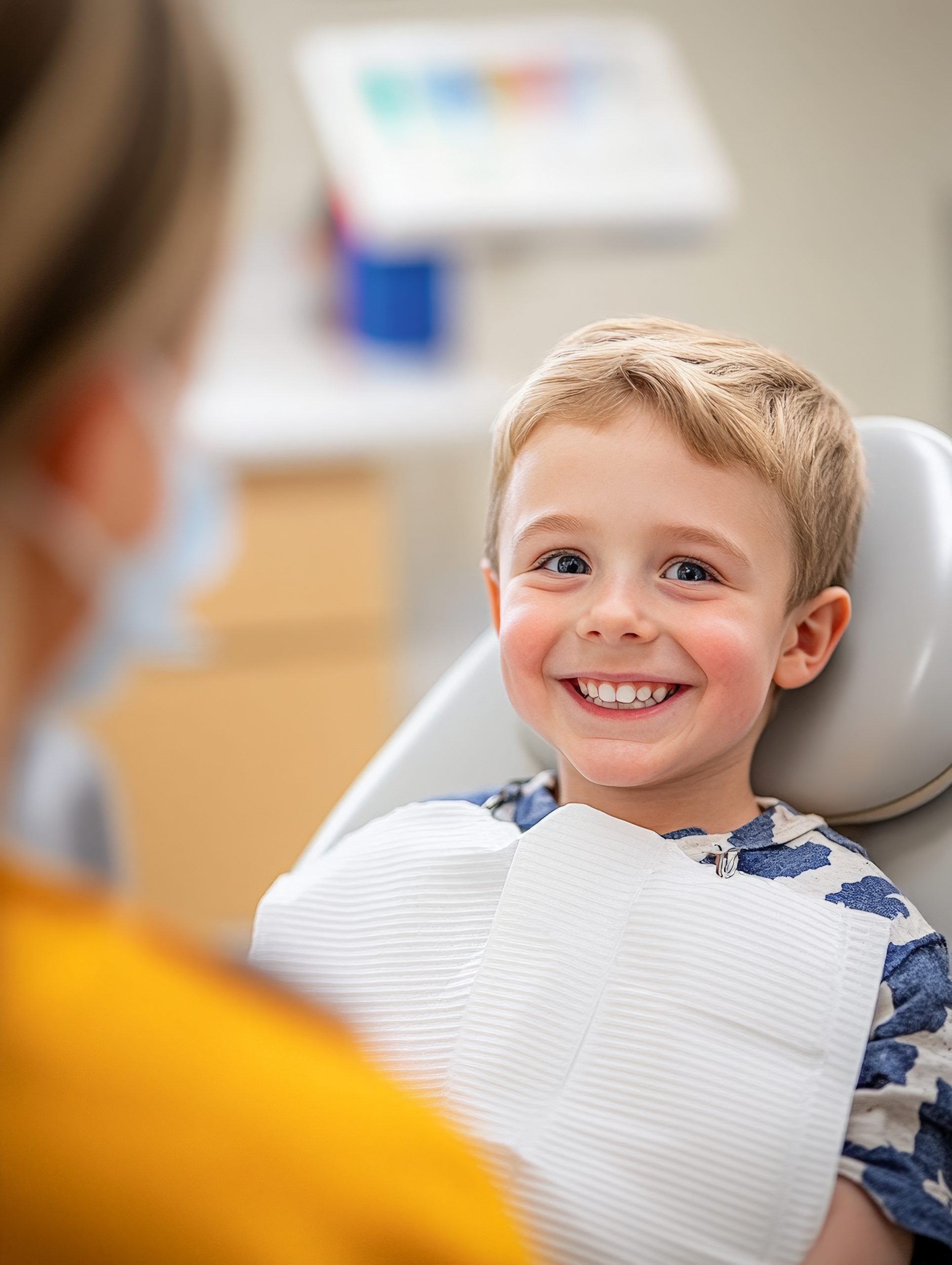Cheerful young boy smiles brightly while visiting the dentist, showcasing a friendly atmosphere in a dental clinic for children's oral health